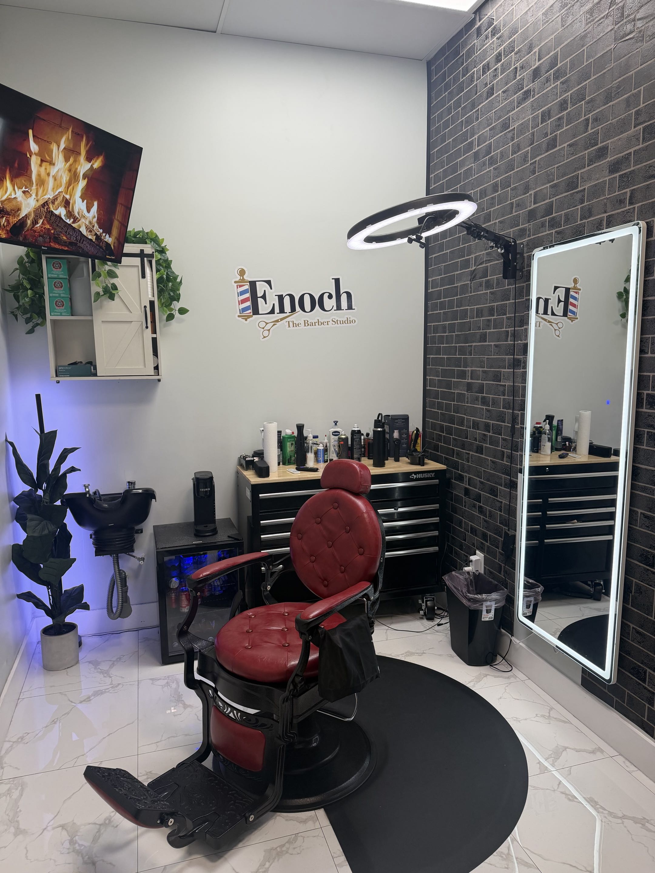 Close view of Enoch The Barber Studio — signature red chair, ring light, and Husky grooming station